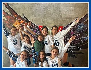 students athletes with arms reaching out in front of mural of wings